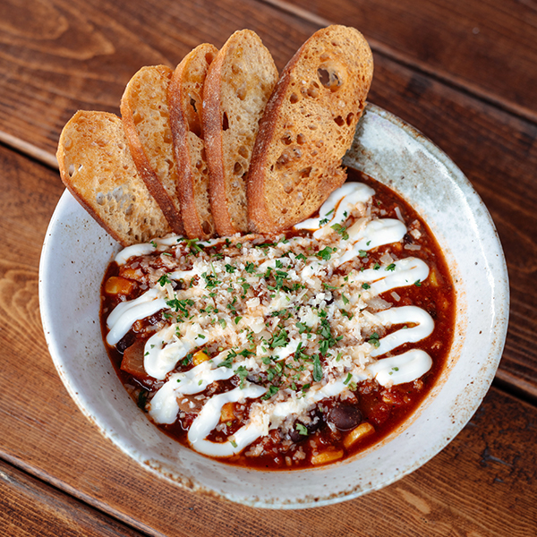 chili con carne chili ground chuck, black beans, corn, sour cream, cheddar, crostini